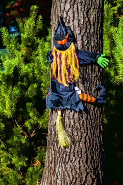 Witch figure crashing into a halloween tree decoration
